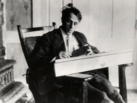 Robert Frost writing at desk ca 1920